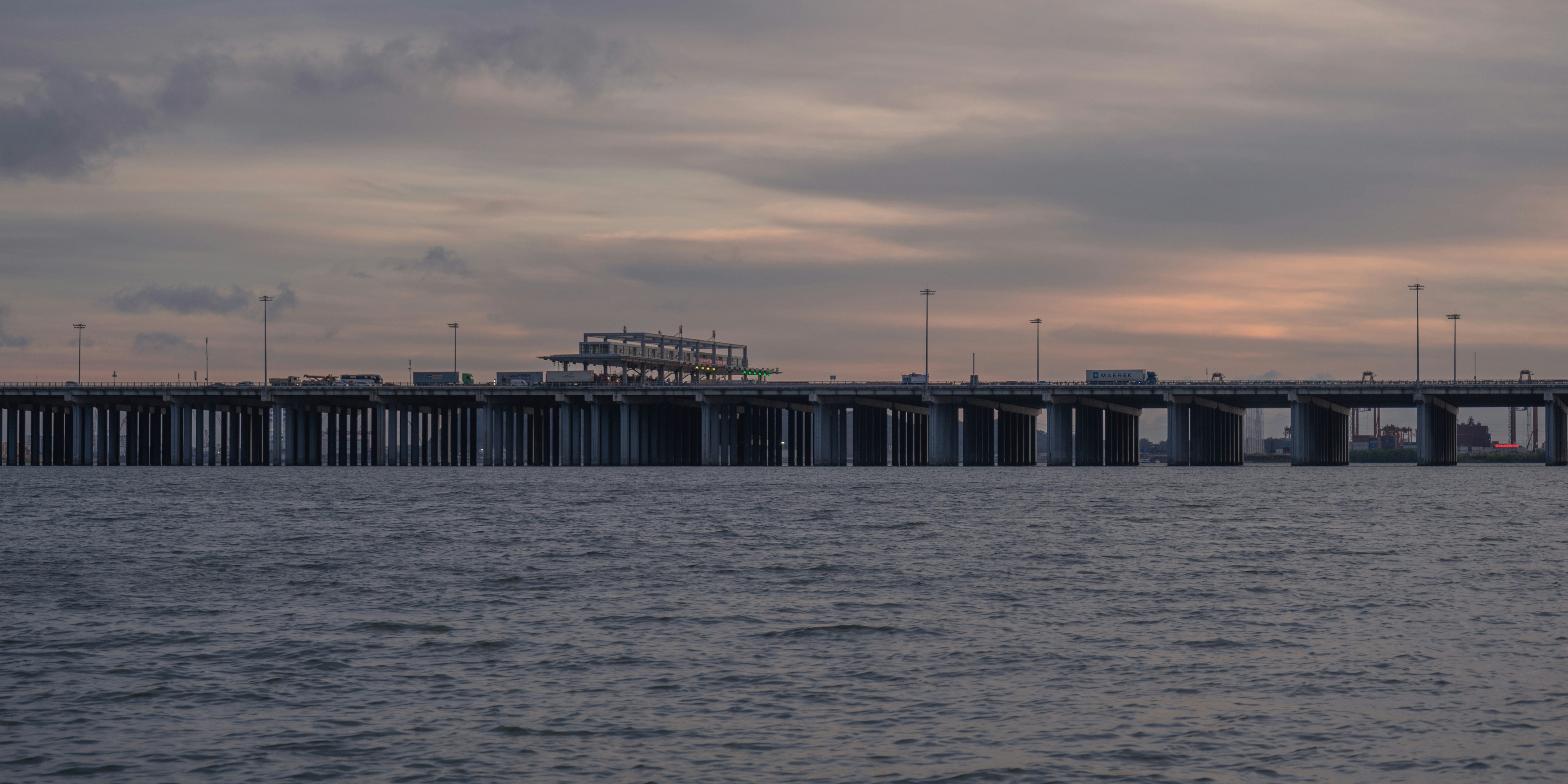 gray concrete bridge over the sea during daytime